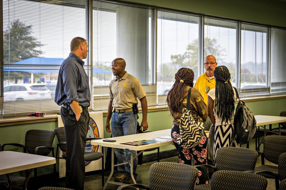 Students speaking to two police officers in a classroom