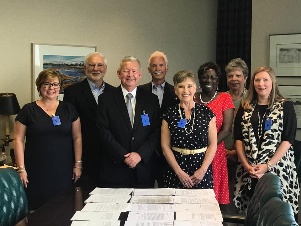 Justice Molly Houseworth Jackson, Justice Neil Burge, Justice Michael White Judge Nelson's wife Angie, Administrative Assistant to the County Judge Cindy George, County Clerk Janice Currie, County Treasurer Peggy Meatte, and Financial Director Kelli Jones smiling for the camera