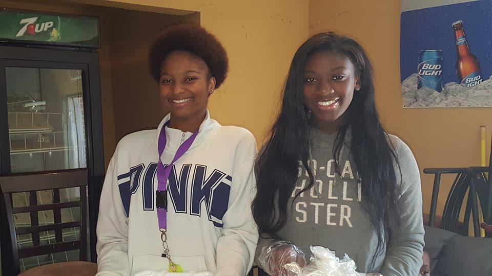 Two women standing together and smiling for the camera