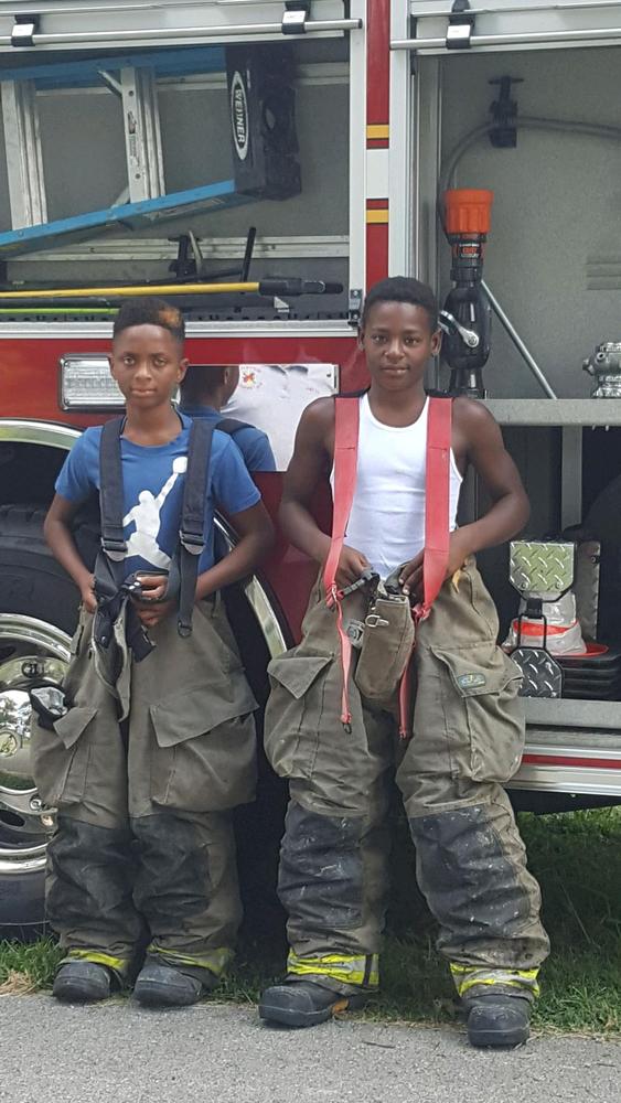 Two children wearing fireman gear